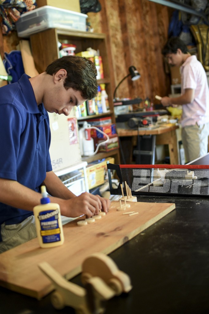 Sam Leppo ’17 assembles parts for the handmade toys he and his brother Logan cut and sanded.